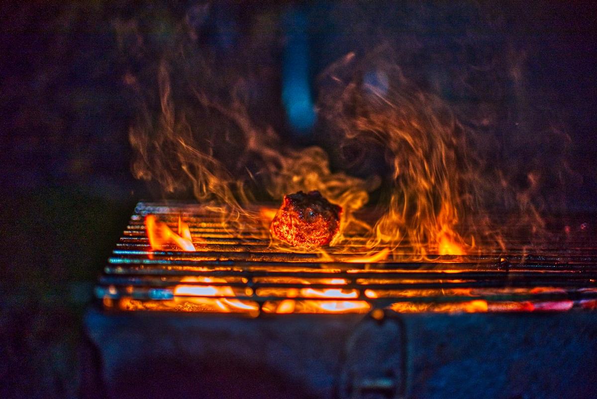 炭火が静かに照らす肉の断面
